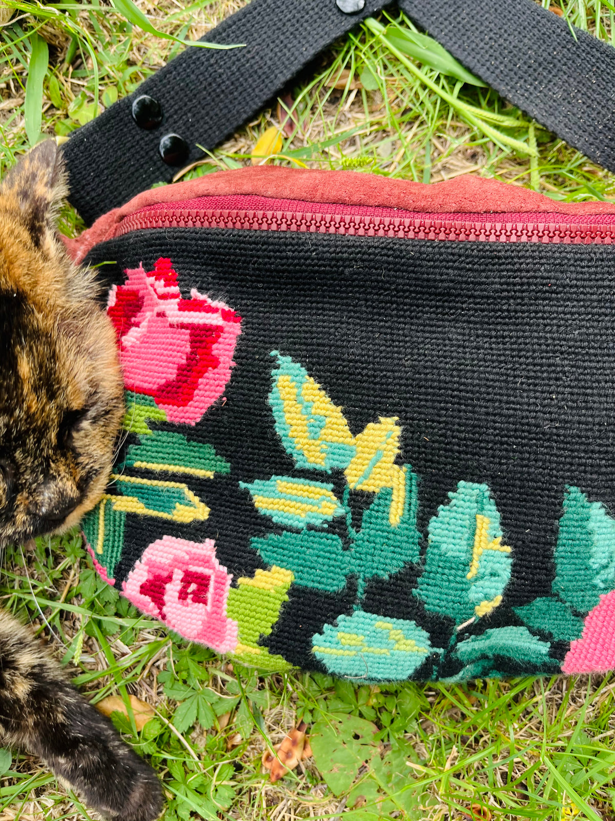 Marsupi con rose su sfondo nero e pelle color melanzana